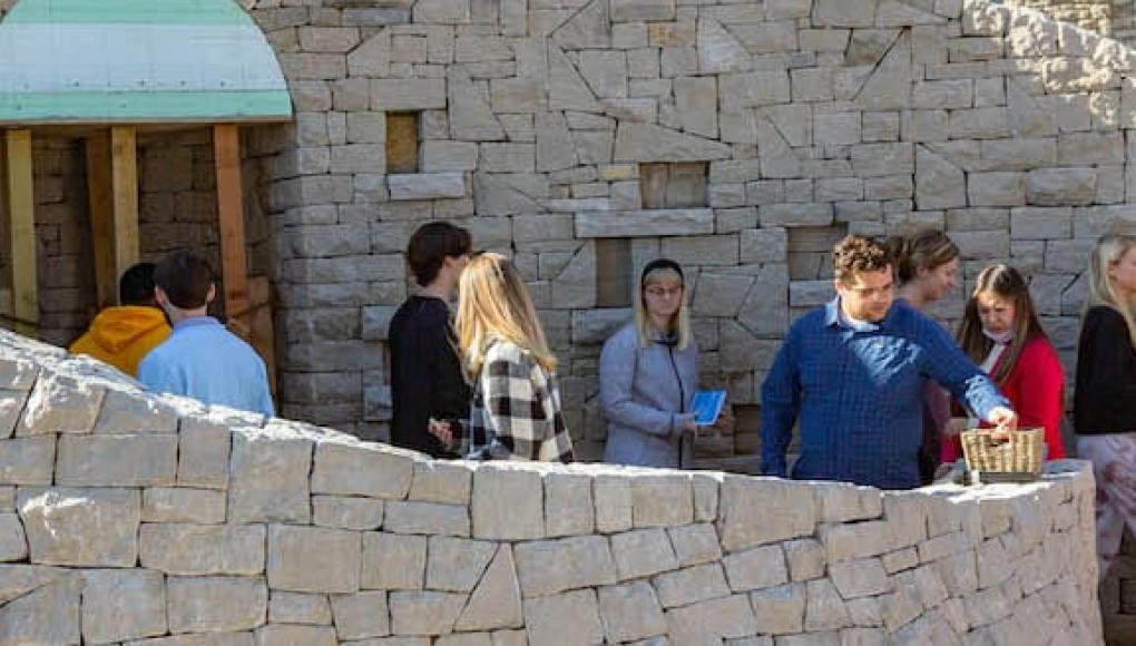 Students look at the nearly finished Mary grotto