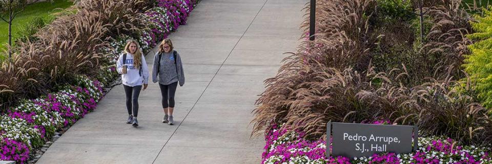 Students walking outside of Arrupe Hall.